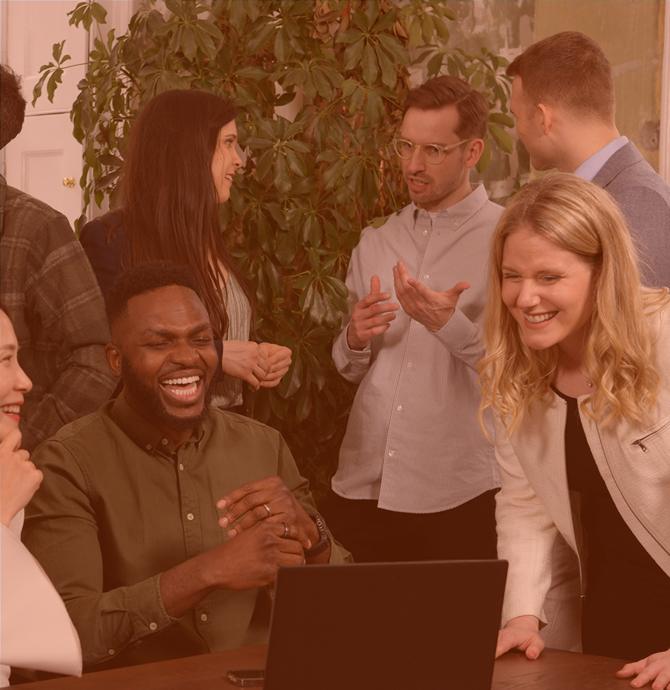 Man smiling surrounded by colleagues