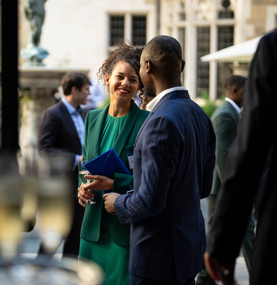 Female standing outside in conversation with male who has his back to the camera