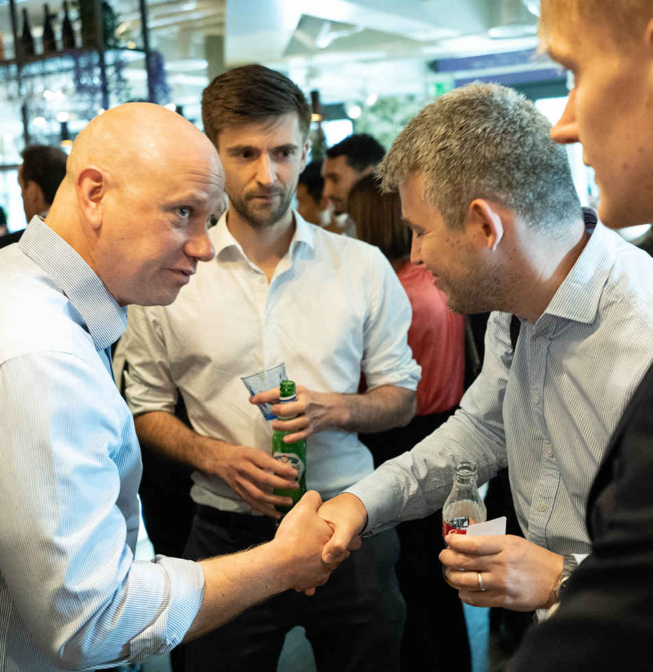 Men smiling and laughing at an event