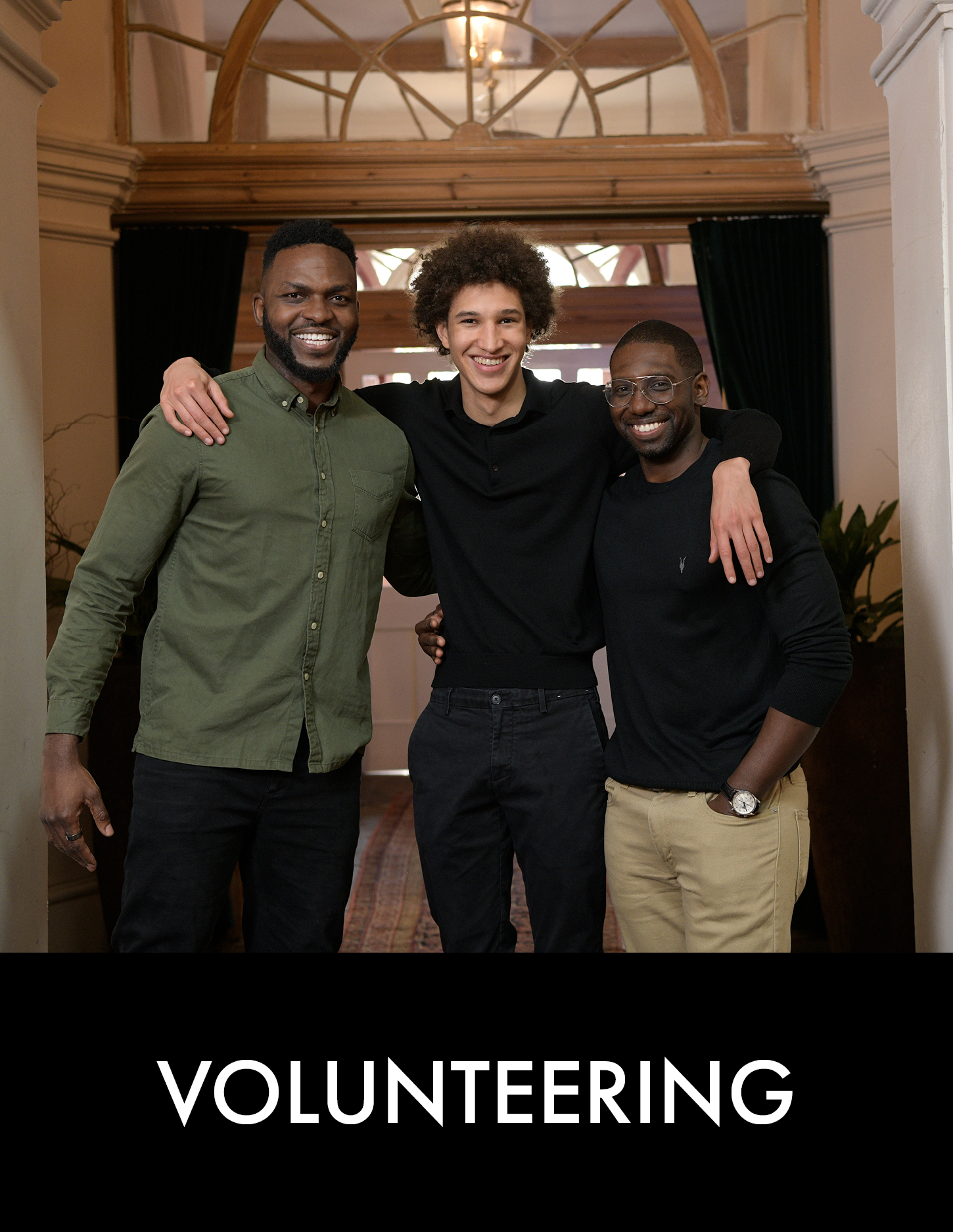 Three men stand together in building foyer